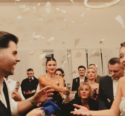 Bride and groom celebrating at a lively indoor wedding reception with friends and family.